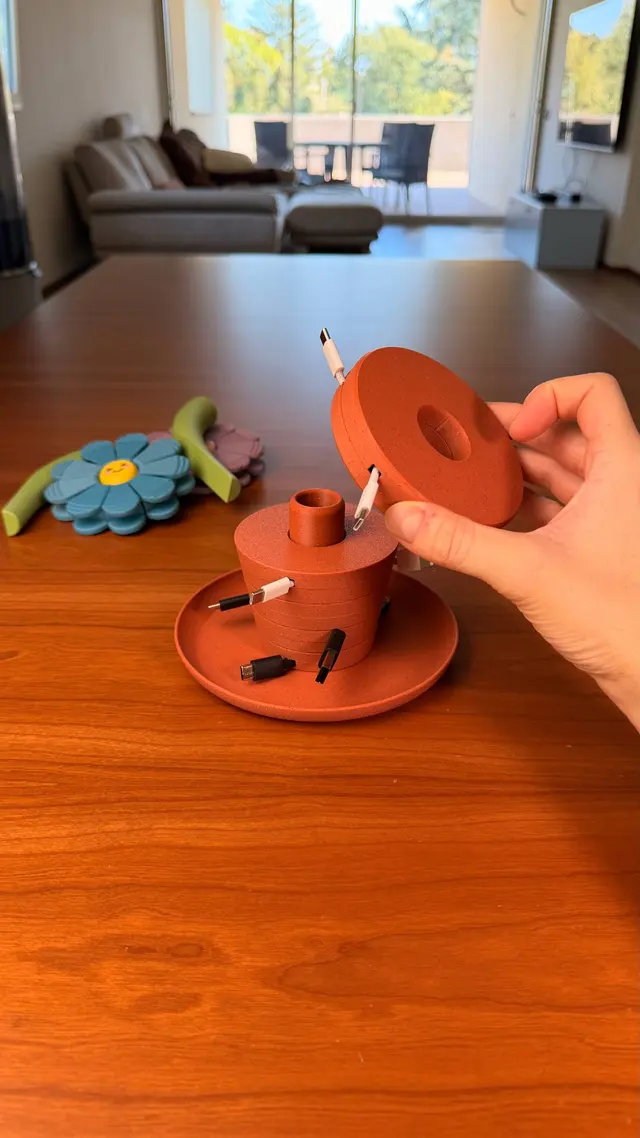 A ring of the Bloom Stack vase held in a hand while it is stacked onto the vase