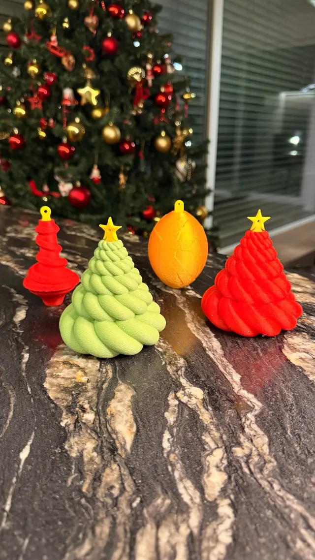 The three Cash Baubles, tree, ball and cone, on the table in front of the Christmas tree