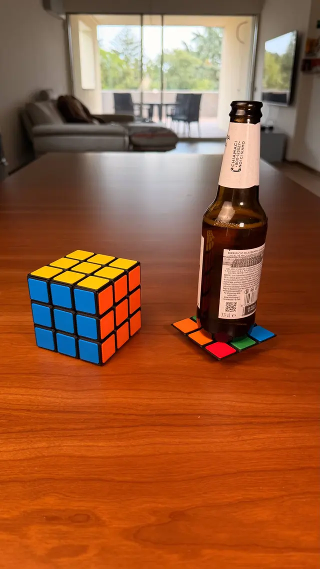 The cube, a coaster and a bottle on the table