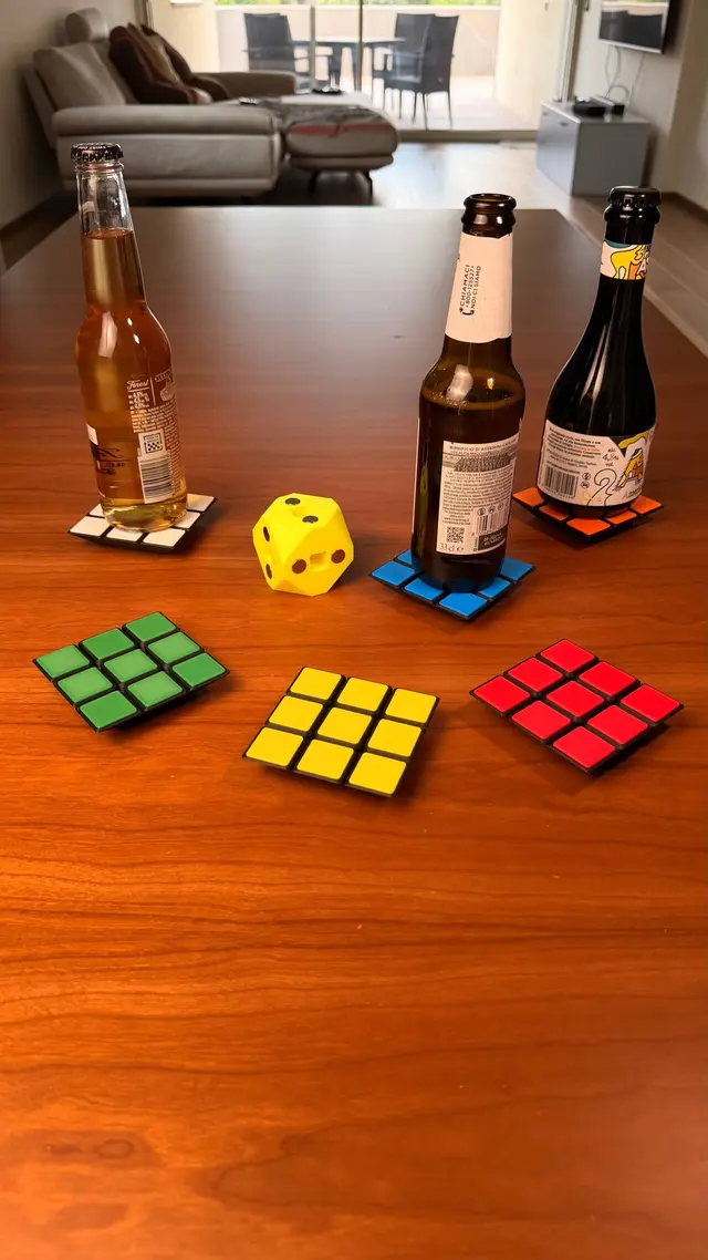 Three coloured coasters on the table, with bottles next to them