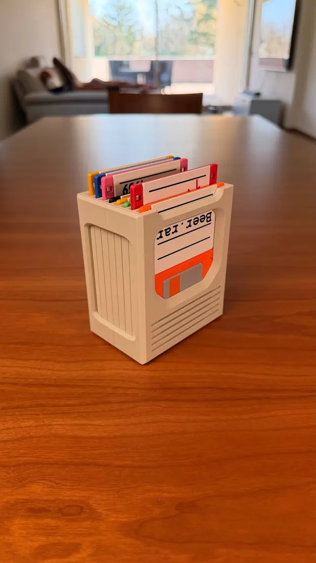 Beige holder standing on a wooden table with coloured floppy disks slotted in from the top