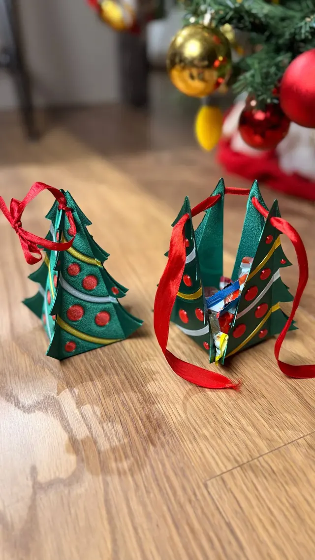 One assembled tree and one being closed with the red ribbon