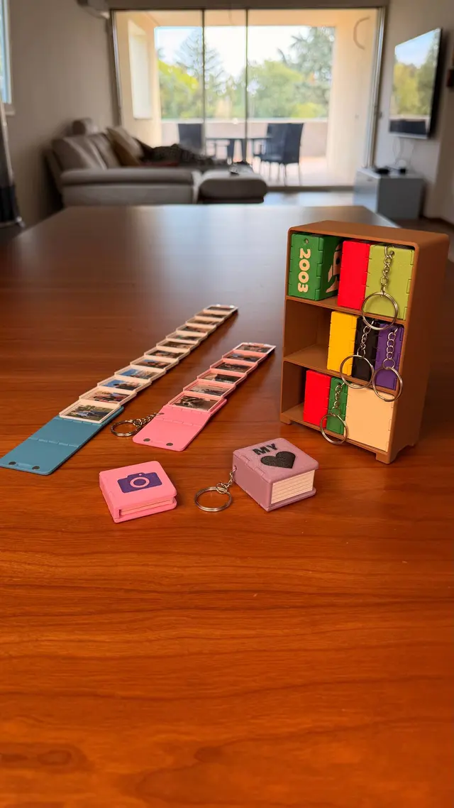 Key Books in several colours on a wooden table, with a row of open pages and the bookcase