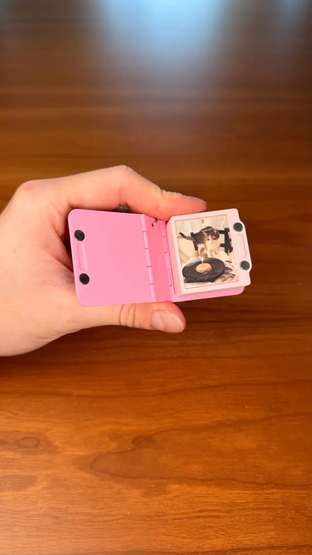 Una mano tiene un Key Book aperto con una foto
