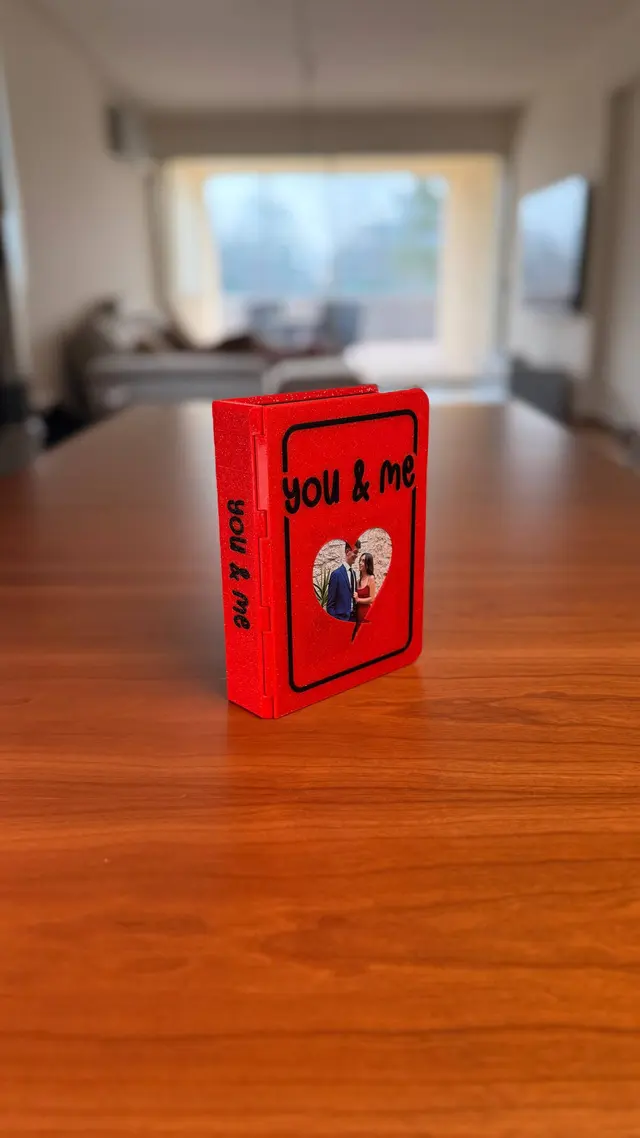 Red Love Book closed, with YOU & ME written on it and a photo inside the heart