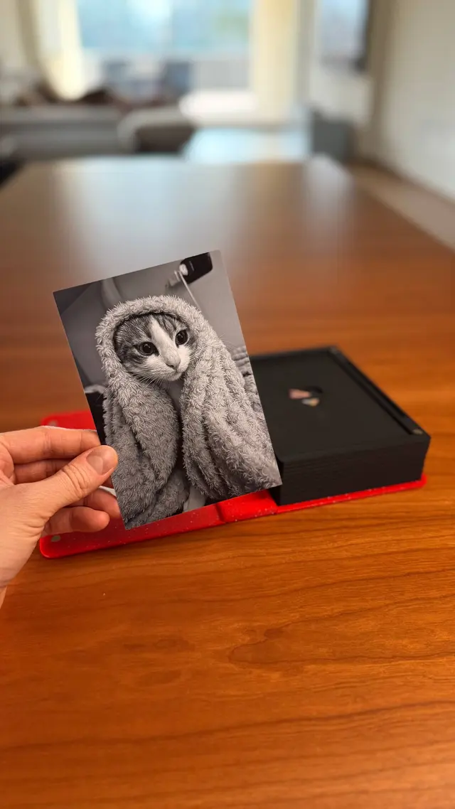 A hand slides a photo into the cover of the Love Book