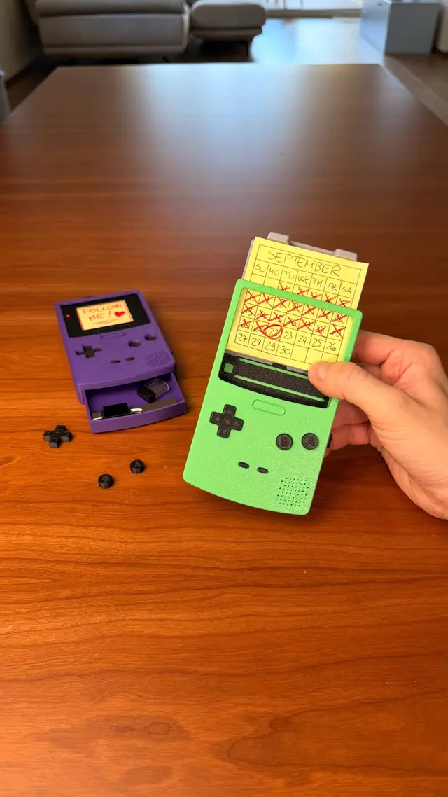 The green Memo Boy with its buttons removed and a purple console in the background