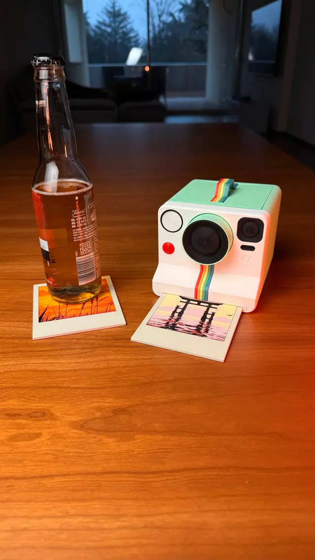 The Memories Coasters camera on the table with a bottle on a coaster