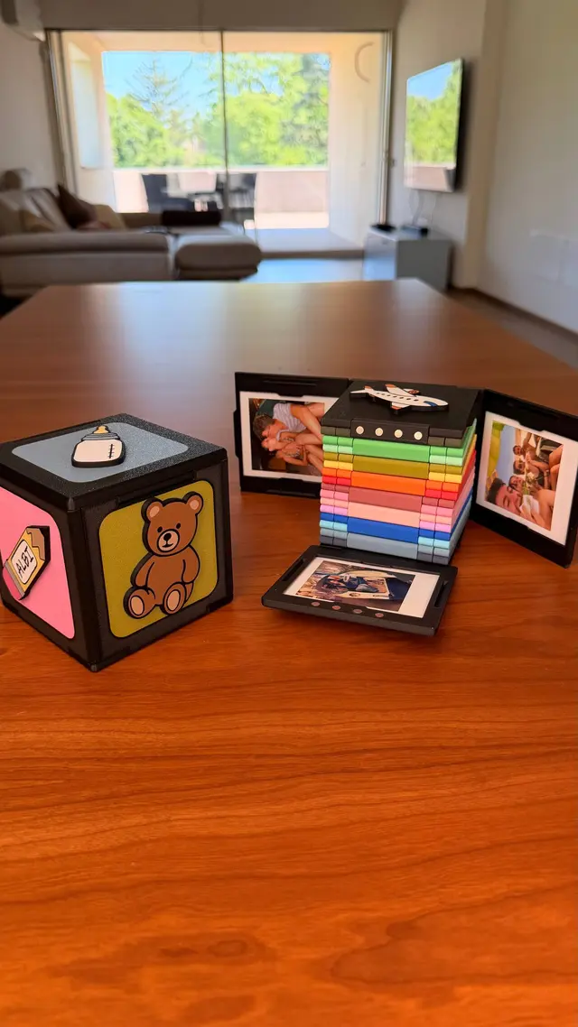 The cube open with its pages full of instant photos