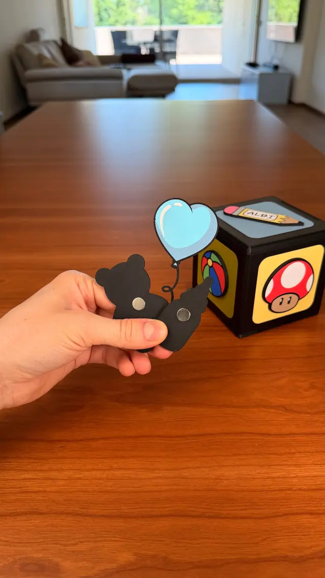 A hand sticks a heart magnet on one face of the cube