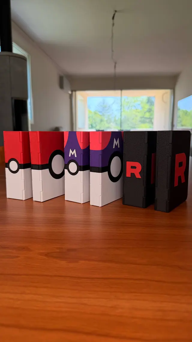 Six closed binders in a row: two with a red and white ball, two with a purple ball, two black with R