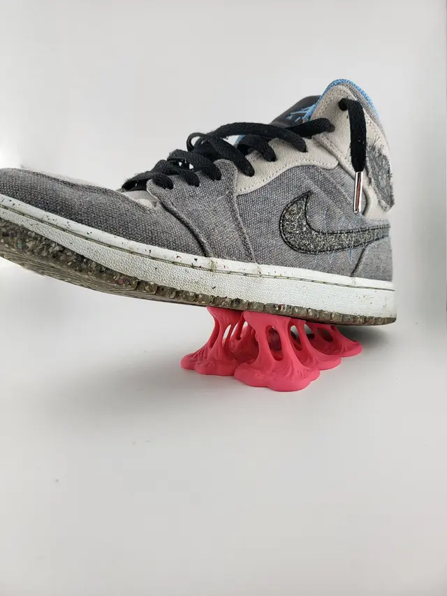 Low Bubble Gum display stand with a grey sneaker