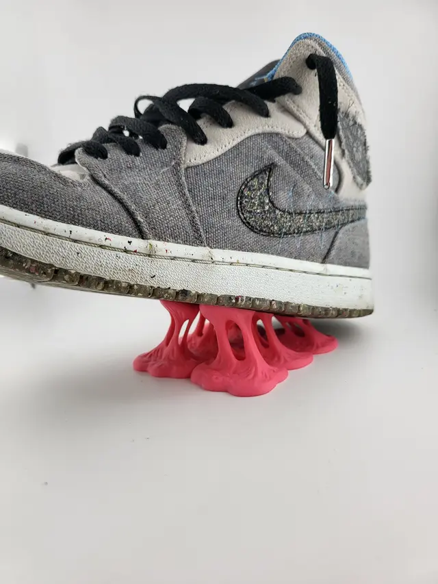 Low Bubble Gum display stand with a grey sneaker, another view