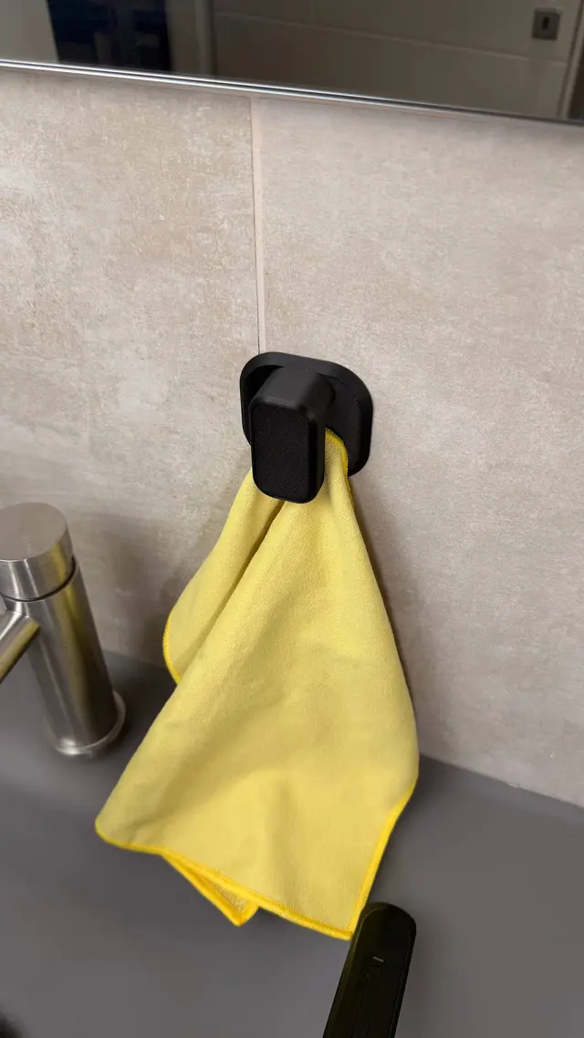 The towel grabber holding a yellow towel