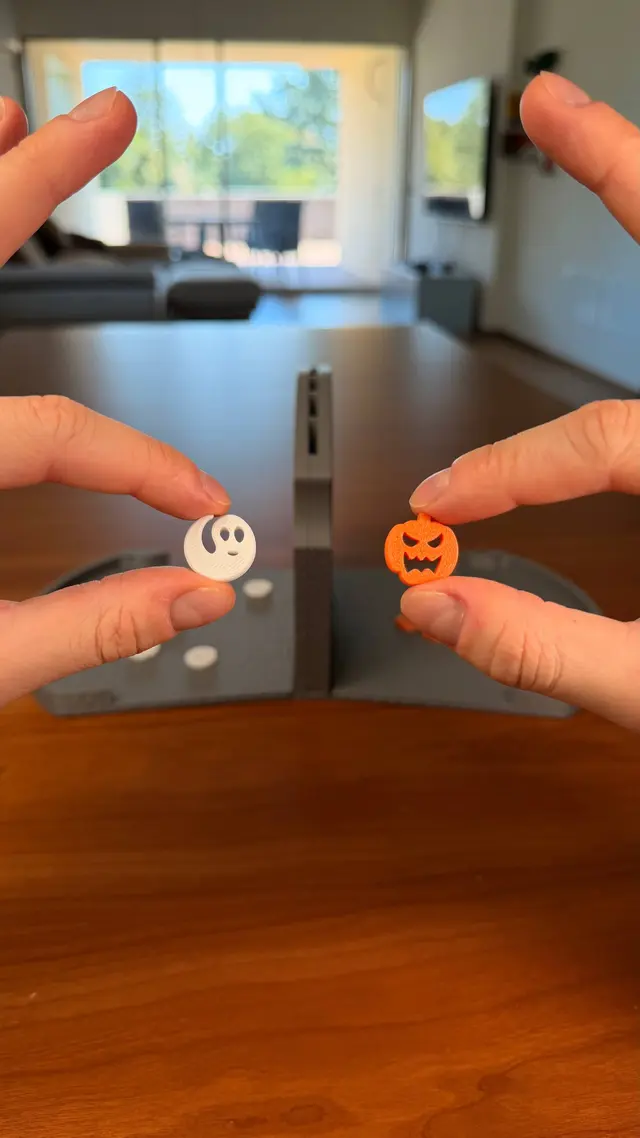 Two hands put in a ghost piece and a pumpkin piece